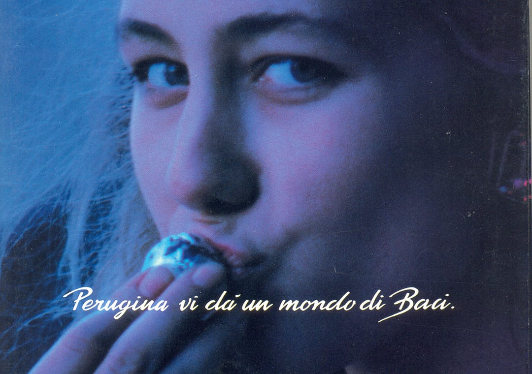 Advertising of blond girl kissing Baci Perugina chocolate