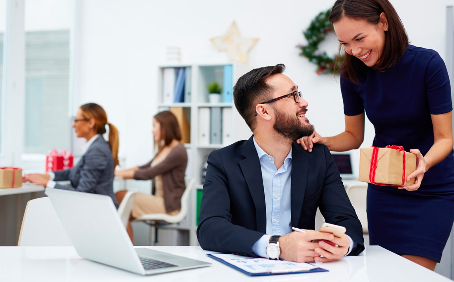 A woman gives a gift to a colleague