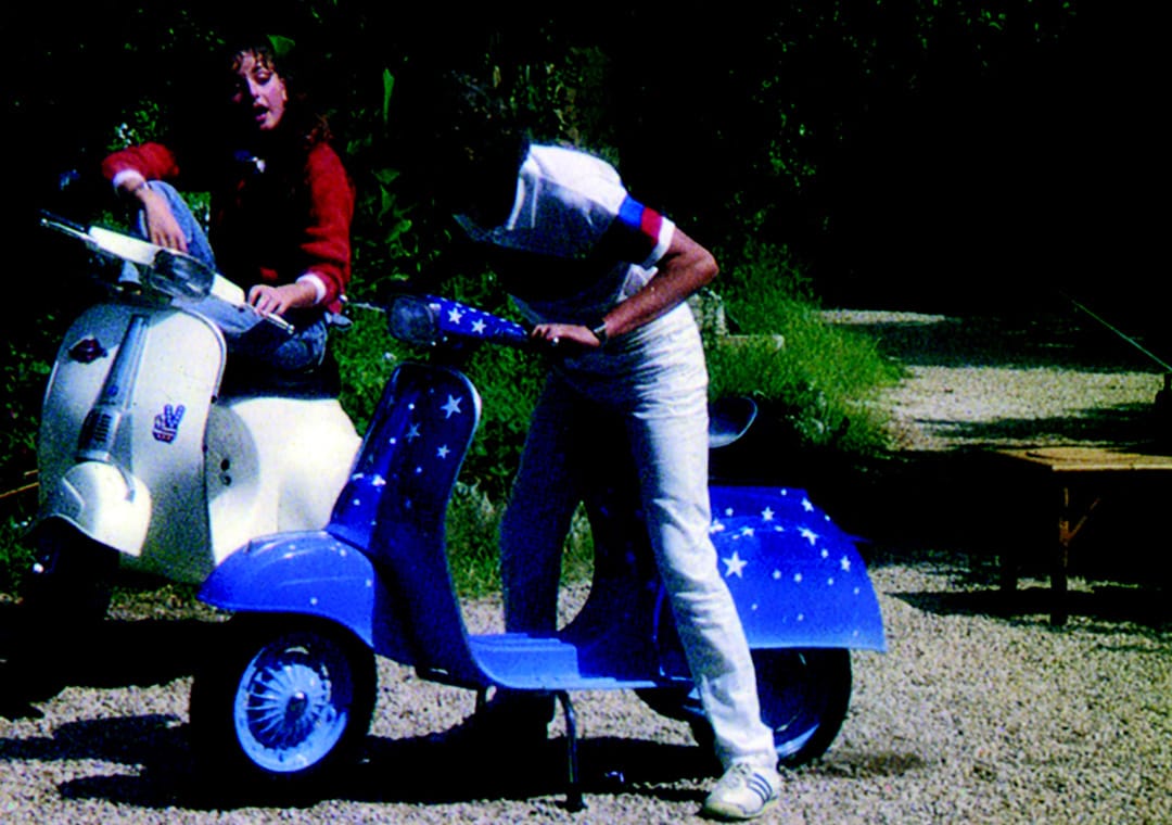 Two young guys on Baci painted scooters