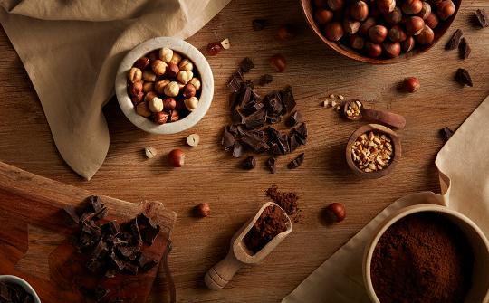 Chocolate, hazelnuts and cocoa scattered on the table
