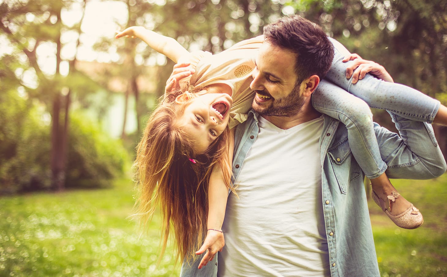 Un papà che gioca con sua figlia nel parco