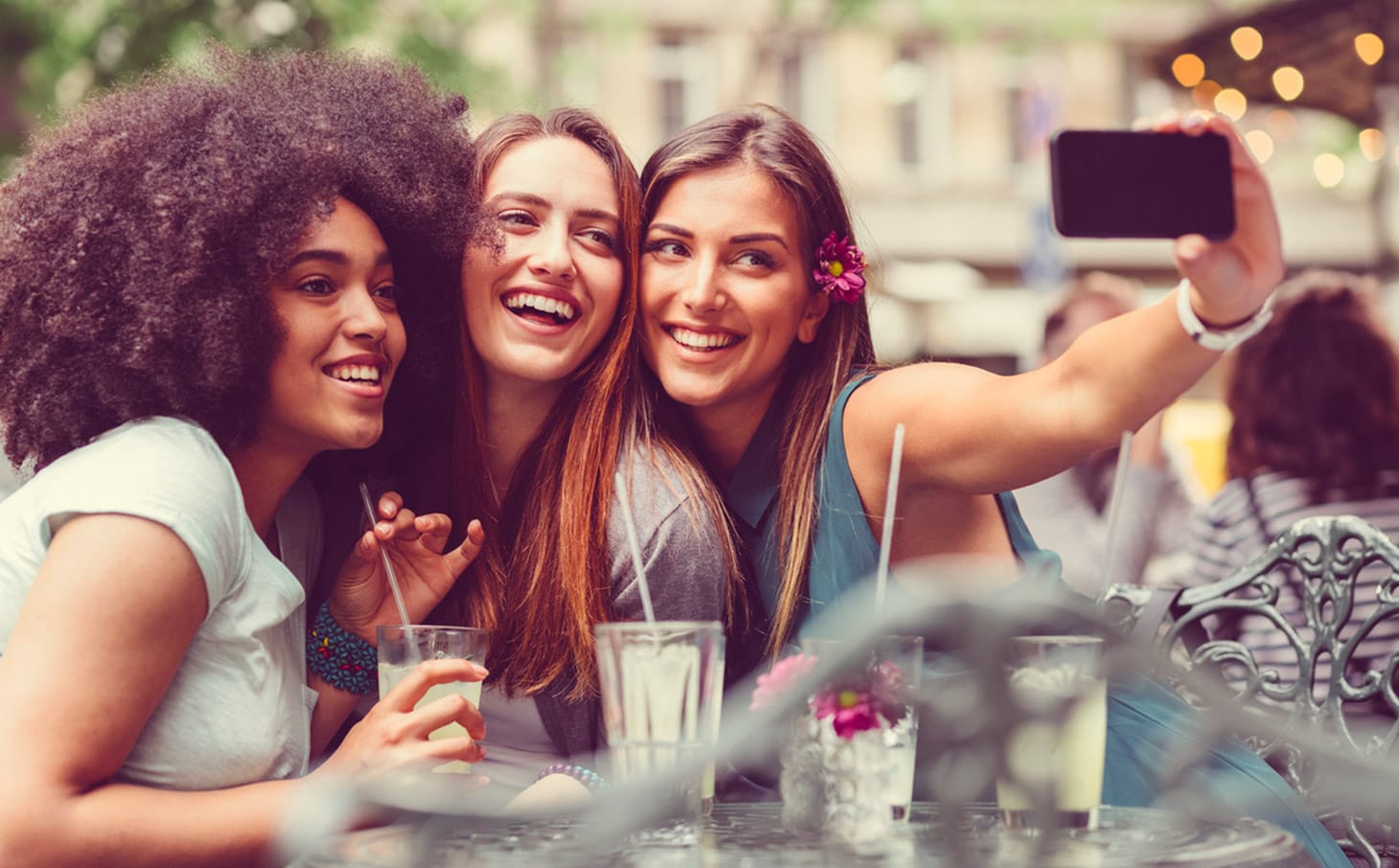 3 amiche si fanno un selfie mentre sono sedute a un tavolino