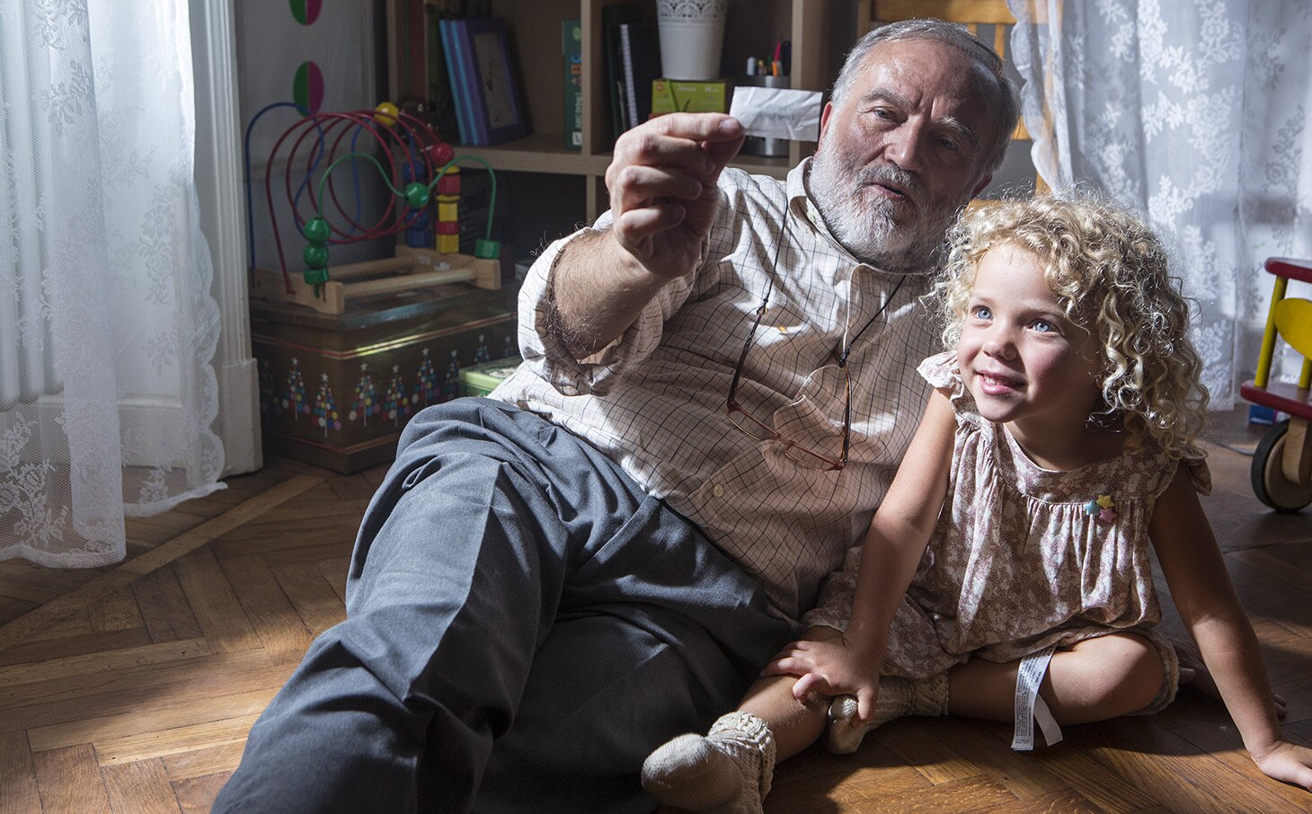 A little girl and her grandfather reading a note of Baci Perugina